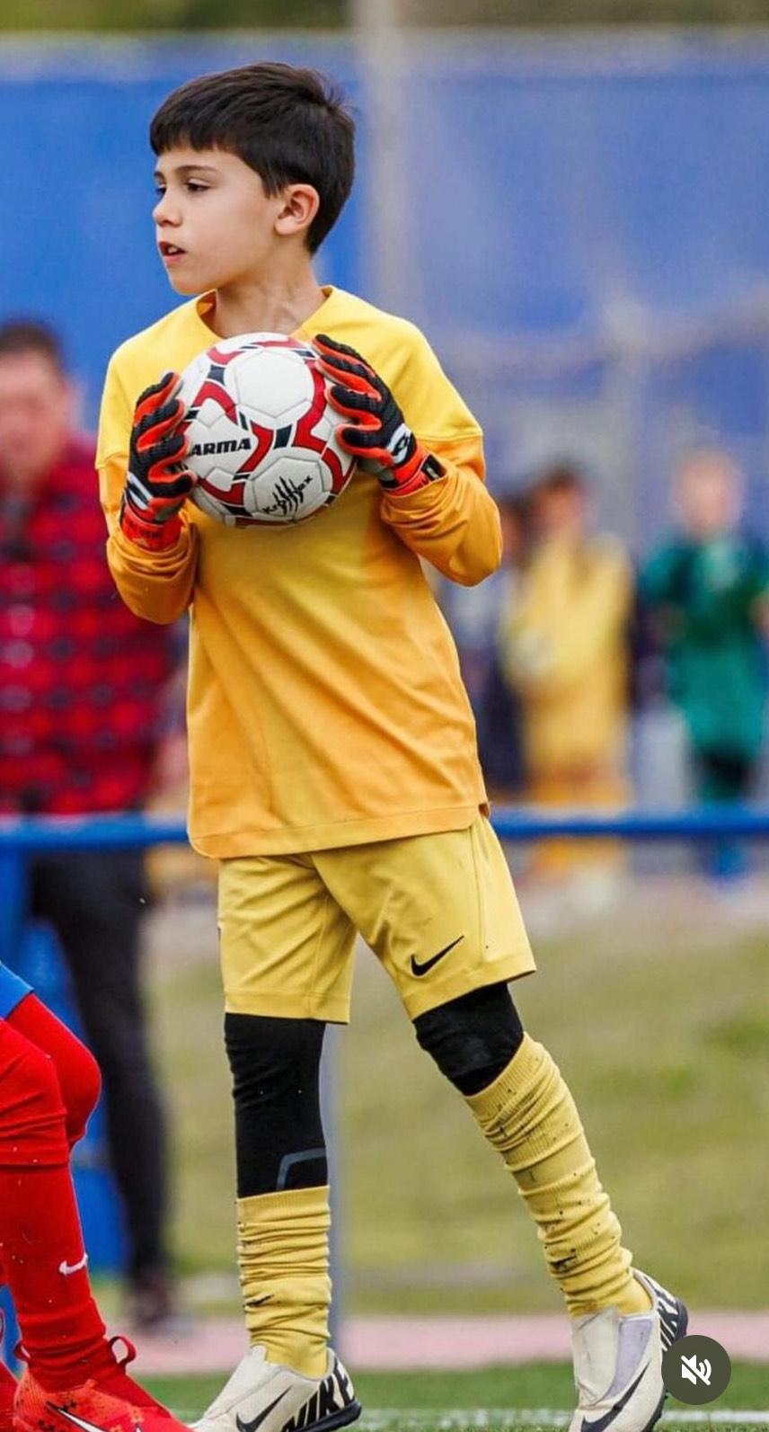 Osemročný Adrián dobýva sociálne siete vášňou pre futbal a brankársky post – aj vďaka produktom z Temu 2 Chlapec v žltom brankárskom drese s loptou v rukách na futbalovom ihrisku.